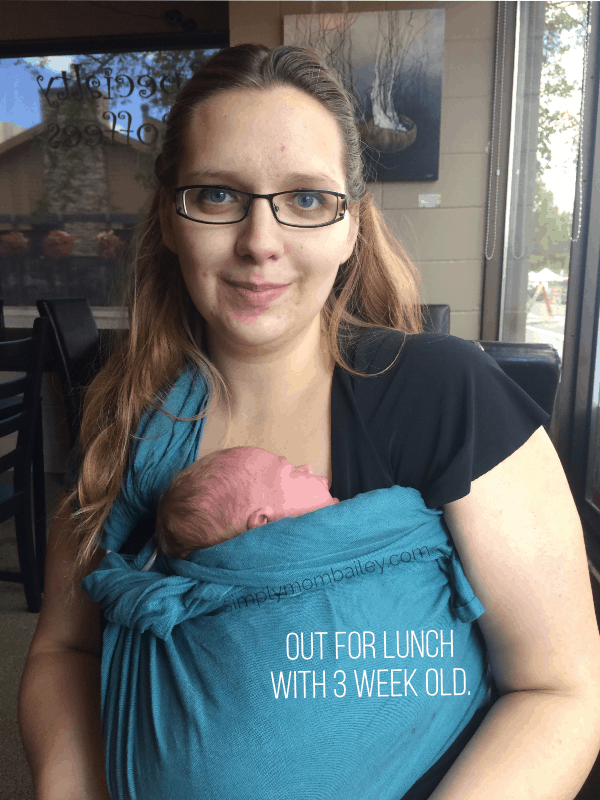 New Mom wearing a baby boy in a blue sling.